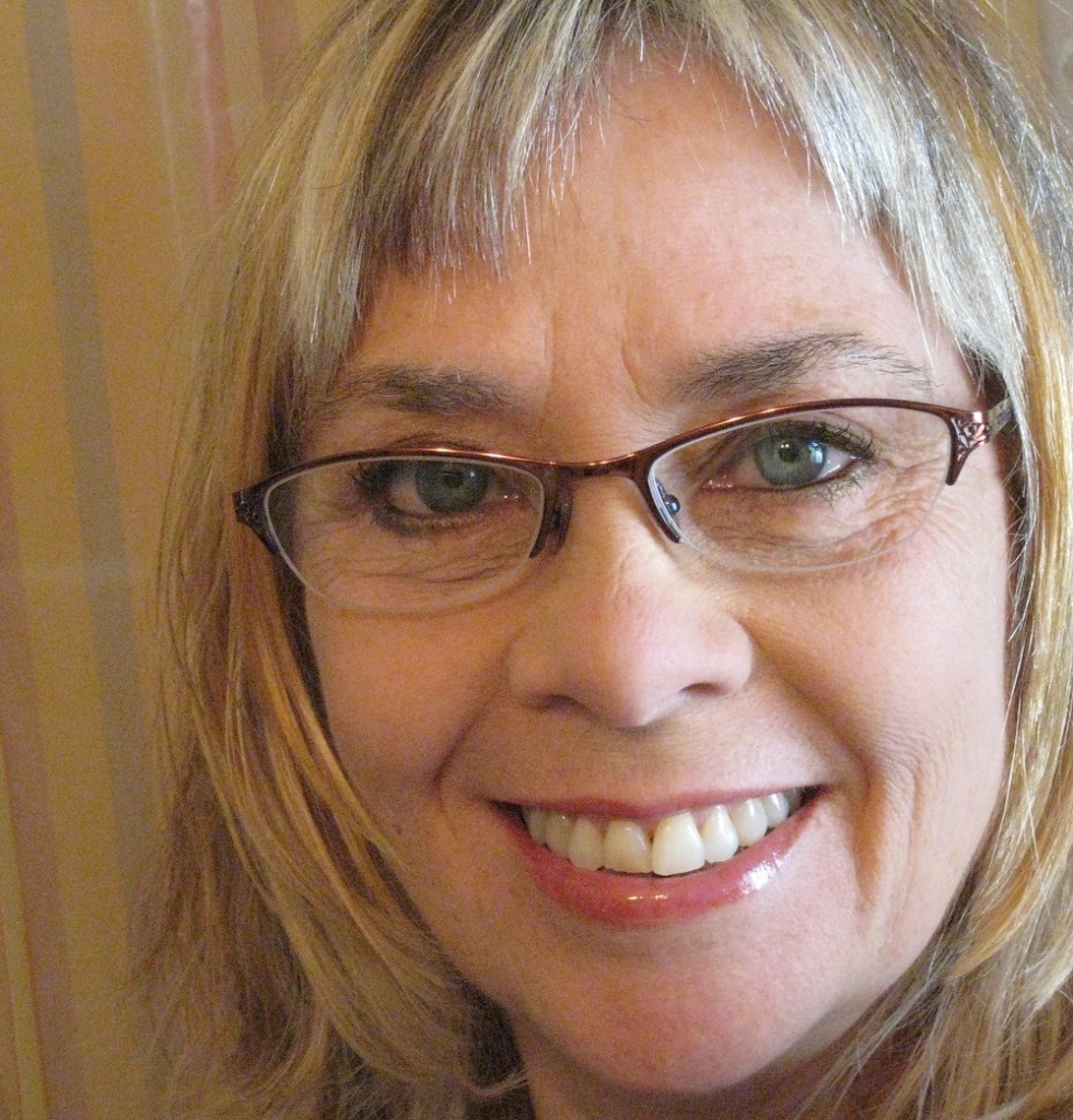 a headshot of Susan. She wears glasses.
